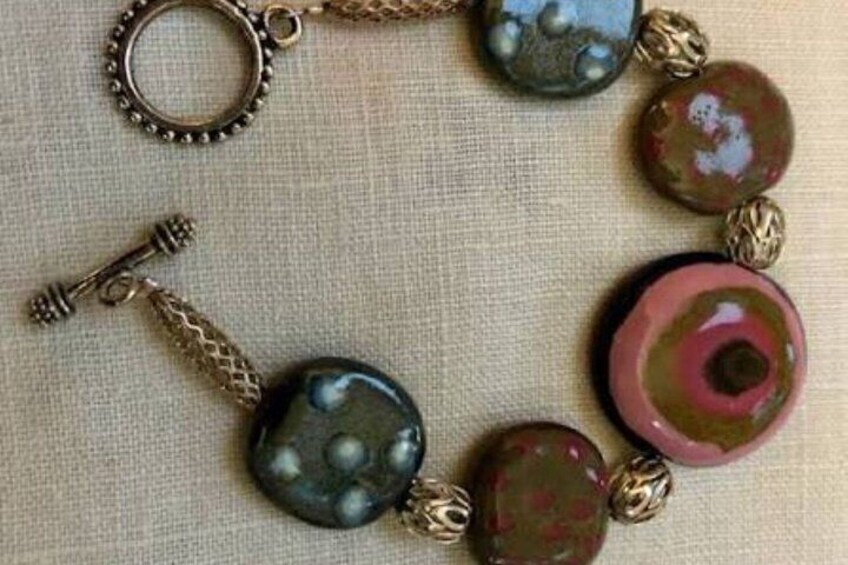 A bracelet with round beads and a key charm. 2