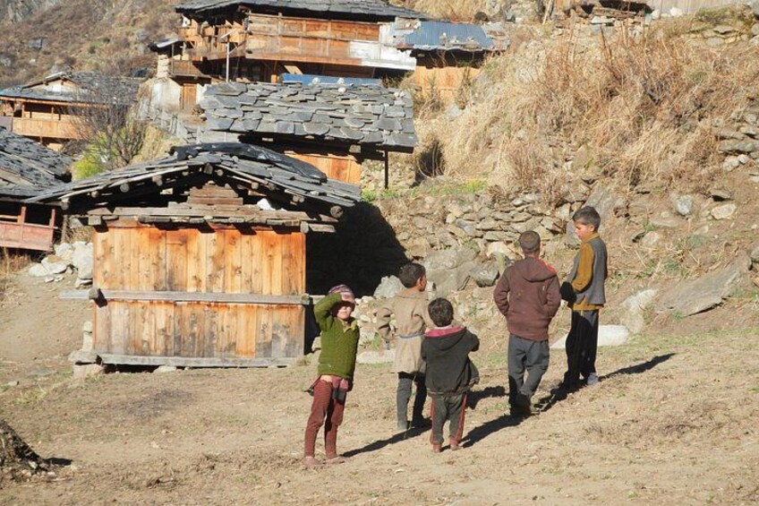 A rural village with wooden houses and a dirt path. 4