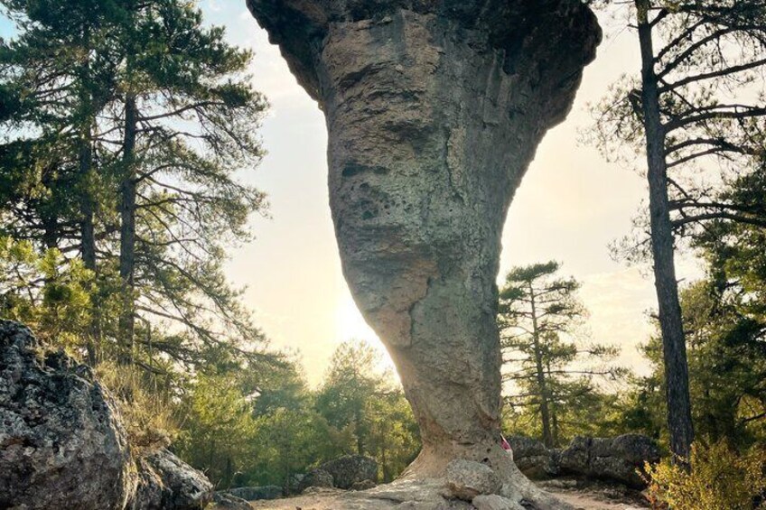 Una gran formación rocosa con un hueco en el centro, rodeada de árboles. 3