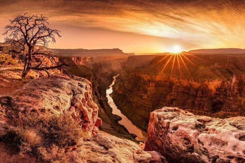 A canyon with a river, rocky cliffs, and a sunset. 4