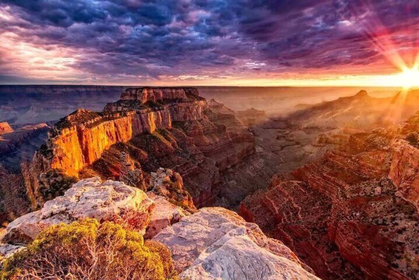 A canyon with layered rock formations and a sunset. 1