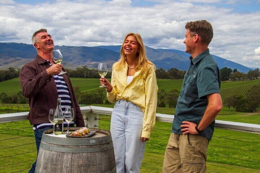 Three people standing outdoors with a scenic landscape in the background. 3