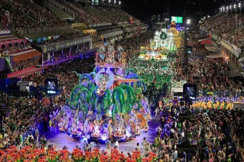 A vibrant parade with a large, illuminated float featuring colorful figures and a crowd of spectators. 3