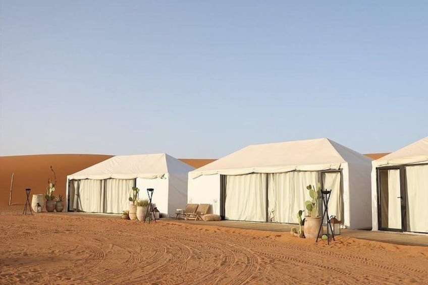 Desert tents with white canopies, surrounded by sand dunes. 4