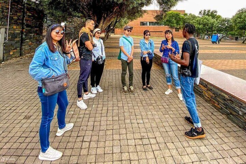 Un grupo de personas de pie sobre un camino de ladrillo en un entorno al aire libre. 2