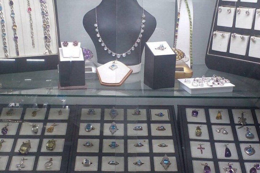 A jewelry display with necklaces, earrings, and brooches on stands and in boxes. 2