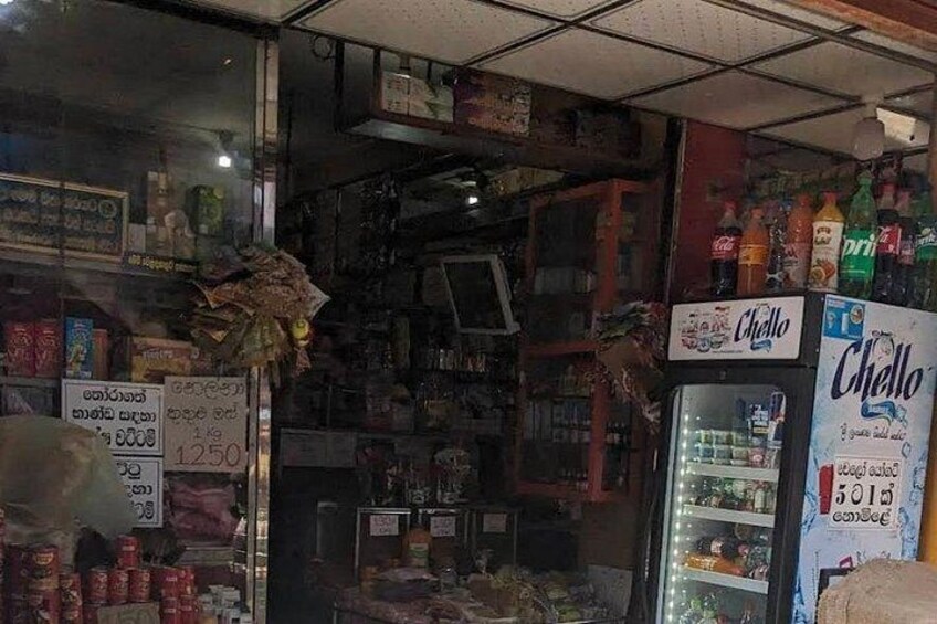 A store interior with shelves stocked with various items, a refrigerator, and a sign indicating a price of 1250. 3