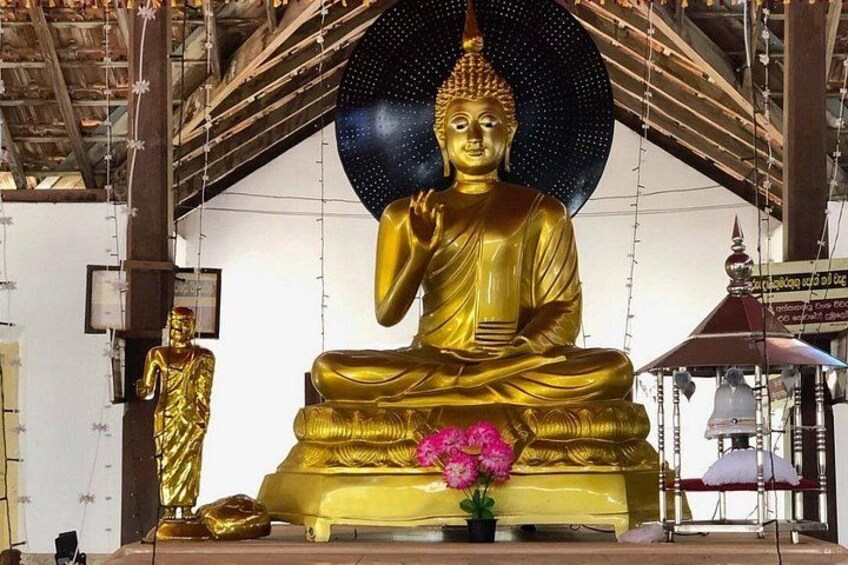 A large golden Buddha statue in a temple setting. 4
