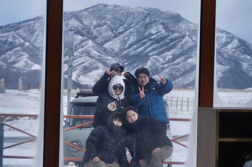 A group of people posing in front of a snowy mountain landscape. 2