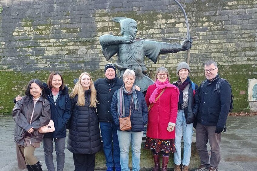A group of people standing in front of a statue. 4