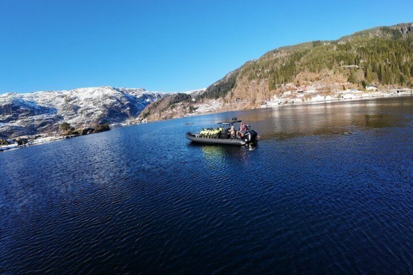 Un bateau sur une rivière paisible, avec des montagnes enneigées en arrière-plan. 2
