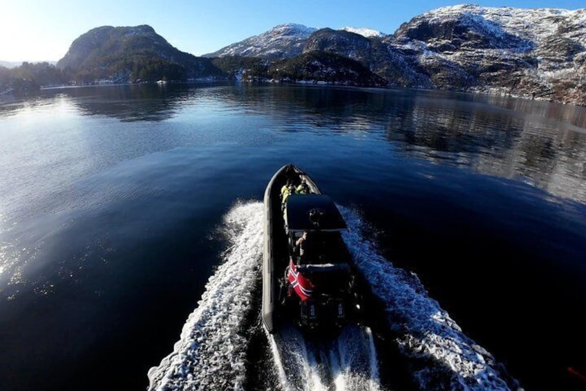 Un bateau navigue sur un lac paisible, avec des montagnes enneigées en arrière-plan. 5