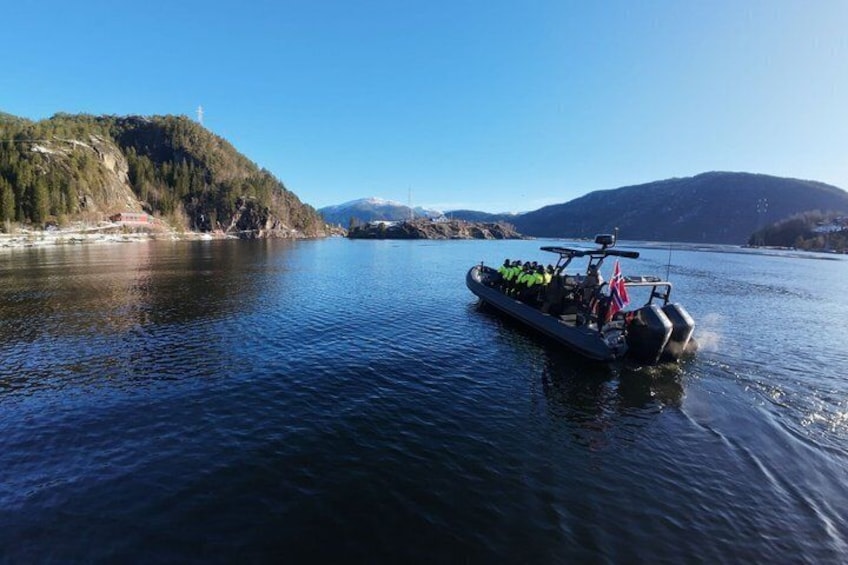 Un bateau transportant des passagers sur un lac paisible, entouré de collines et sous un ciel dégagé. 4