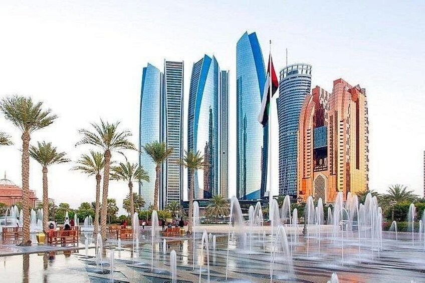 Un paysage urbain avec des gratte-ciel modernes, une fontaine et des palmiers. 3