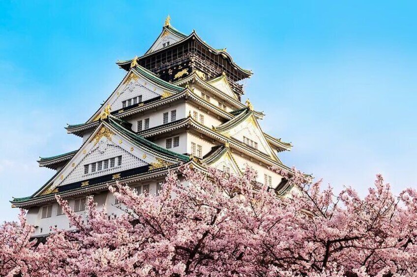A traditional Japanese castle with multiple tiers and golden accents, surrounded by cherry blossoms. 2