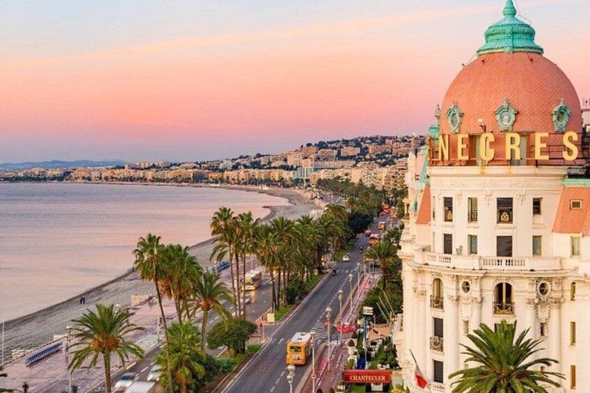 Un paisaje urbano costero con un edificio destacado identificado con 'NECRES' y una playa bordeada de palmeras. 2
