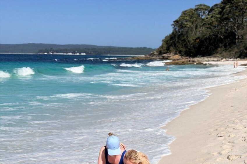 A beach with waves, a sandy shore, and a forested area in the background. 3