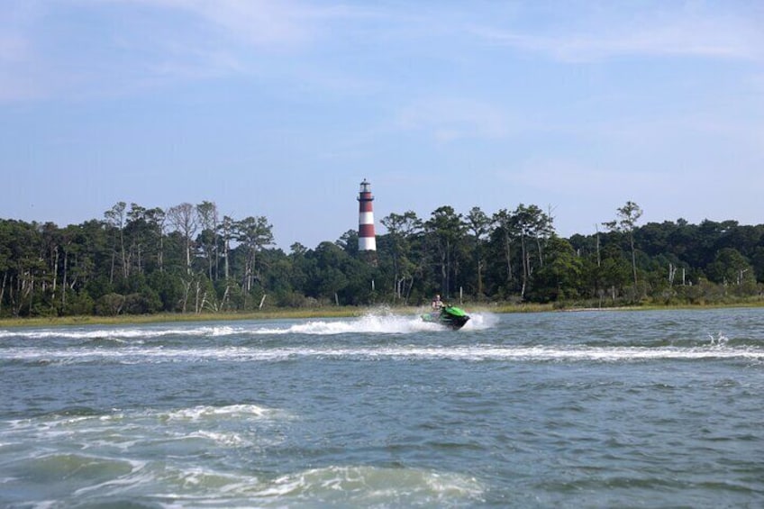 Ein Jetski auf dem Wasser, im Hintergrund ein Leuchtturm. 4