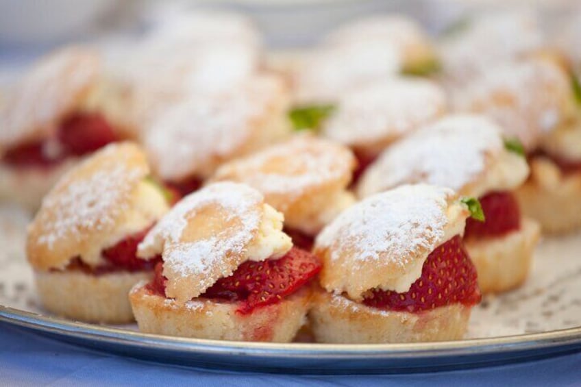 A plate of strawberry shortcake pastries with powdered sugar. 4
