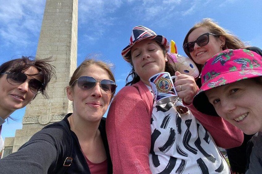 A group of people taking a selfie with a tall monument in the background. 5