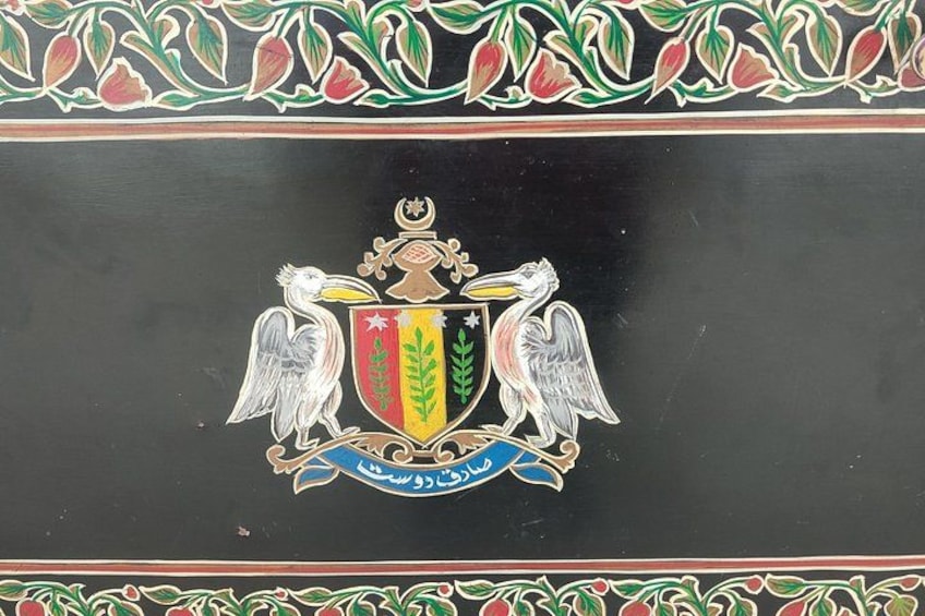 A coat of arms with a shield, two eagles, and a crown. 2