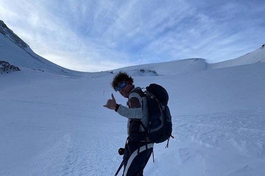 Eine Person wandert mit Rucksack durch eine verschneite Landschaft. 5