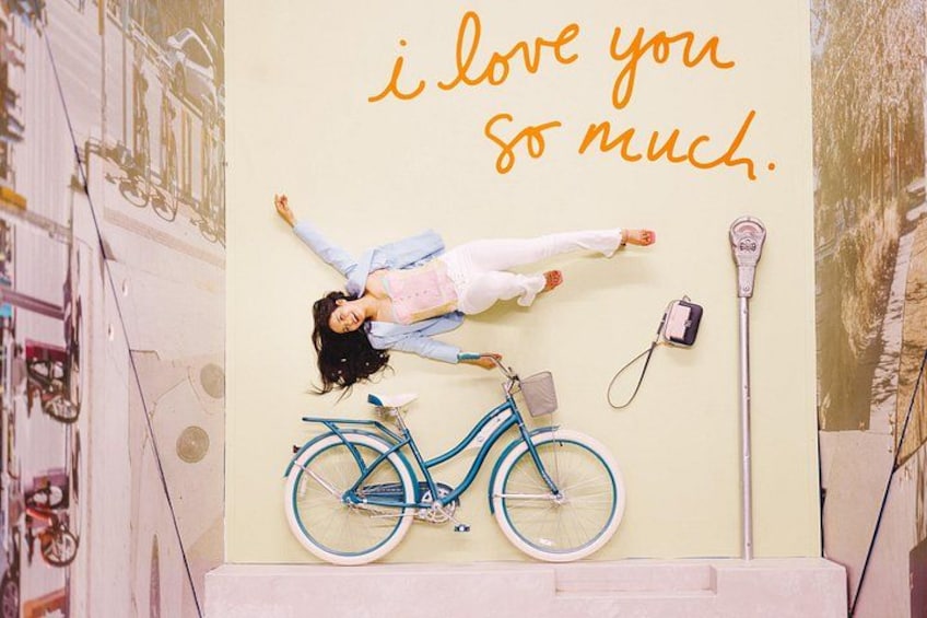 A person lying on a wall with a bicycle and a wall-mounted camera. 1