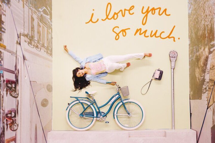 A person lying on a wall with a bicycle and a camera. 1