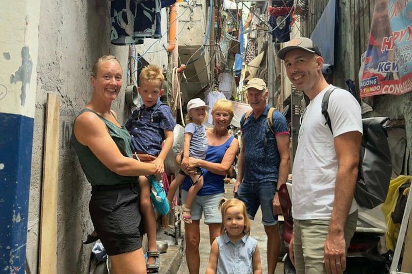 A group of people in a narrow alleyway with buildings on either side. 2