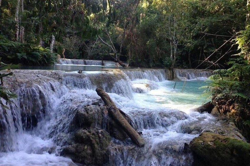 A waterfall cascading over rocks in a forested area. 4