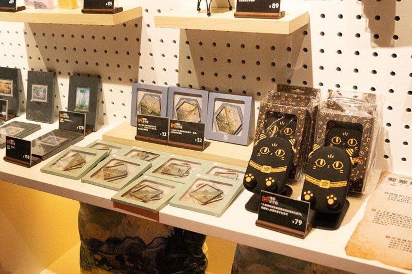 A display of various items including framed pictures, a cat-shaped object, and a book with a price tag. 4