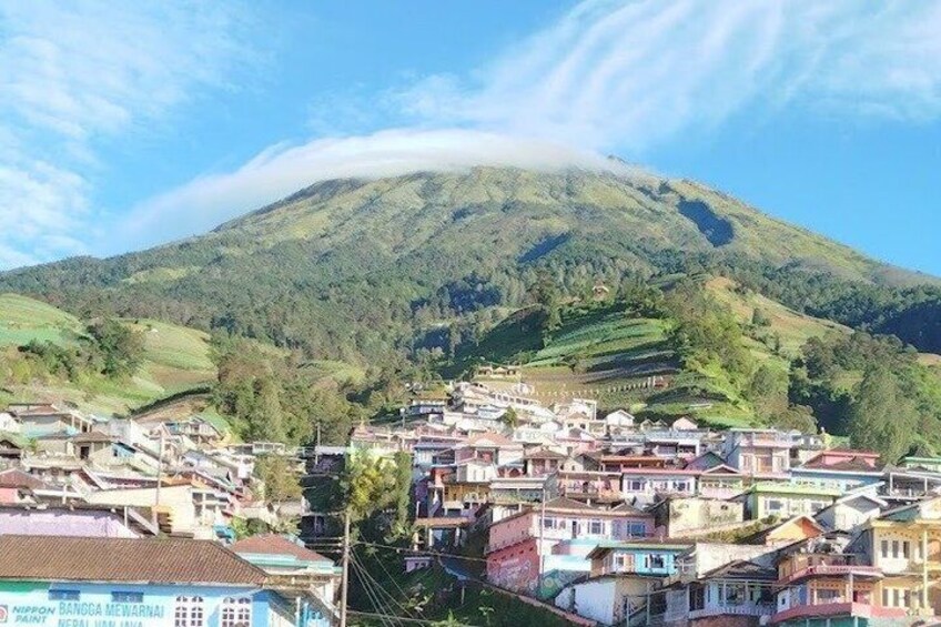 Un pueblo enclavado en un valle con una montaña imponente al fondo. 1