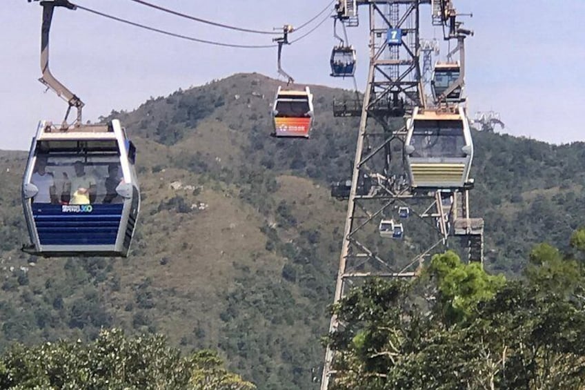 A cable car system with cabins suspended by cables against a mountainous backdrop. 2