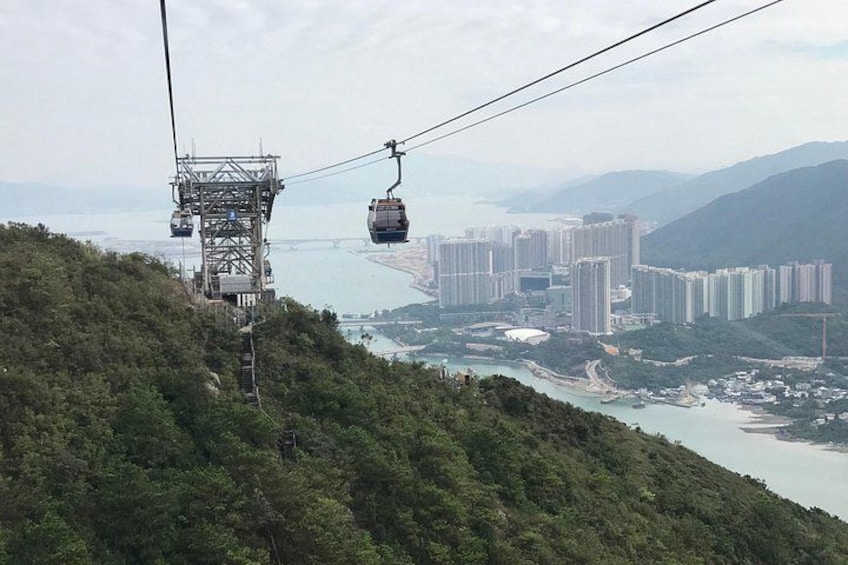 A cable car system, a mountainous landscape, and a cityscape with buildings. 2
