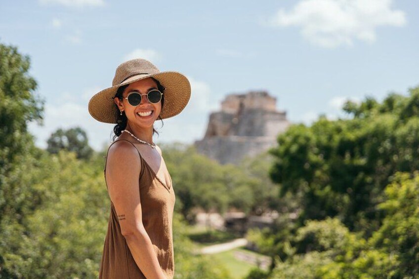 A person wearing a straw hat and sunglasses, standing outdoors with a mountainous landscape in the background. 5