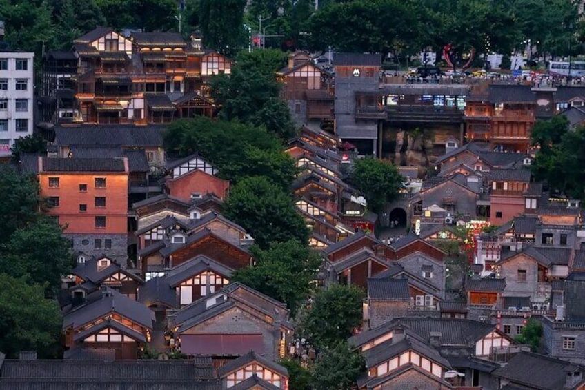 Una zona urbana densa con edificios tradicionales y modernos, rodeada de árboles. 5