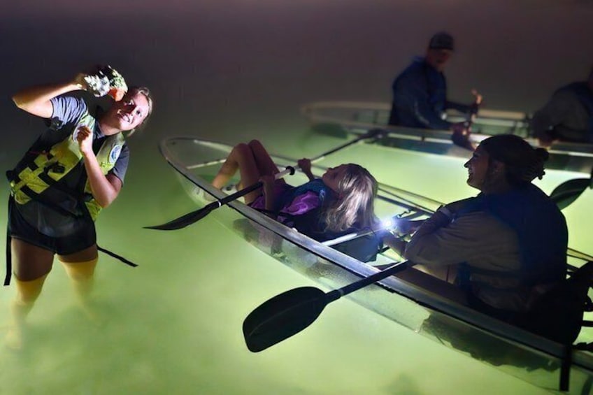 People in a boat on a green-lit water body. 4