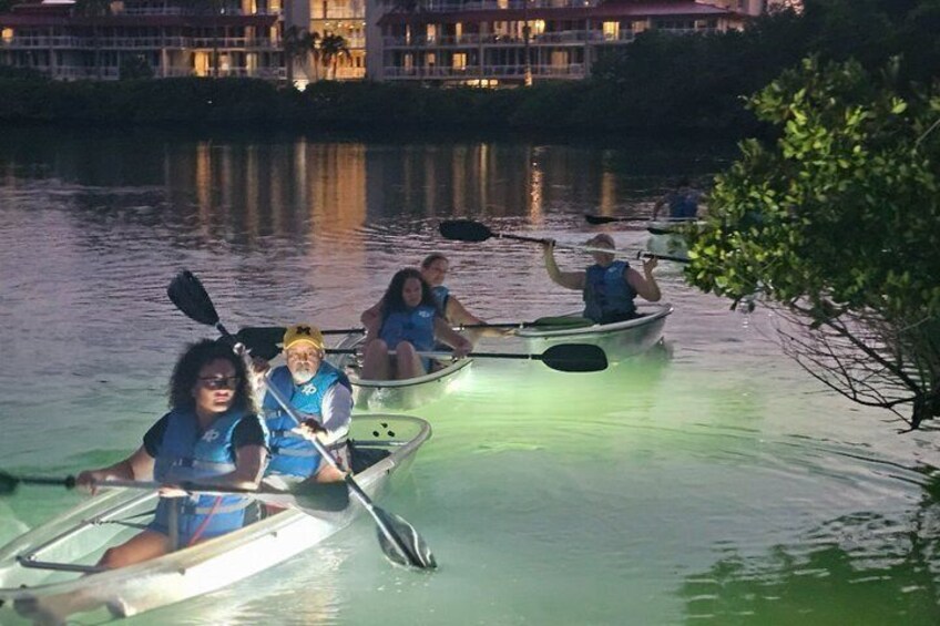 People paddling in canoes on a calm body of water at dusk. 3