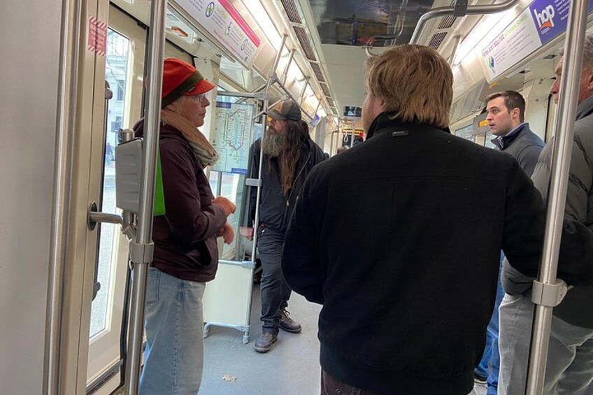 Ein überfüllter Zug mit Fahrgästen, die sich an den Haltestangen festhalten. 2
