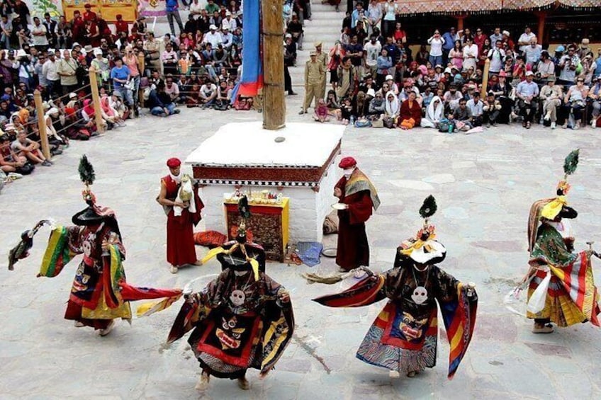 A group of performers in traditional costumes dancing in a public square. 2