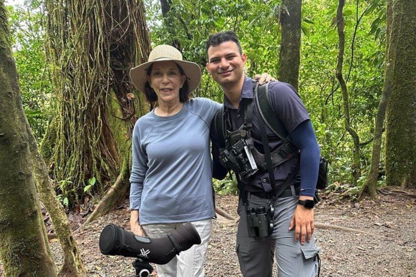 Two people in a forested area with moss-covered trees and a person carrying a backpack. 2