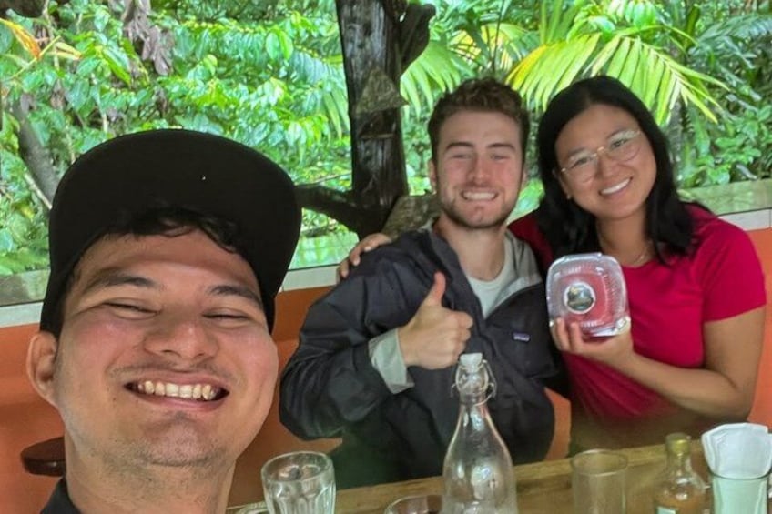 Three people sitting at a table with a tropical background. 4