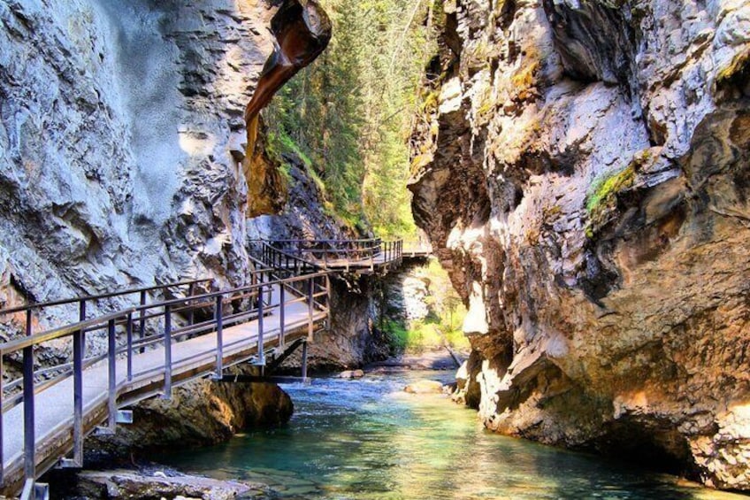 A bridge over a river in a rocky canyon with a wooden walkway. 4