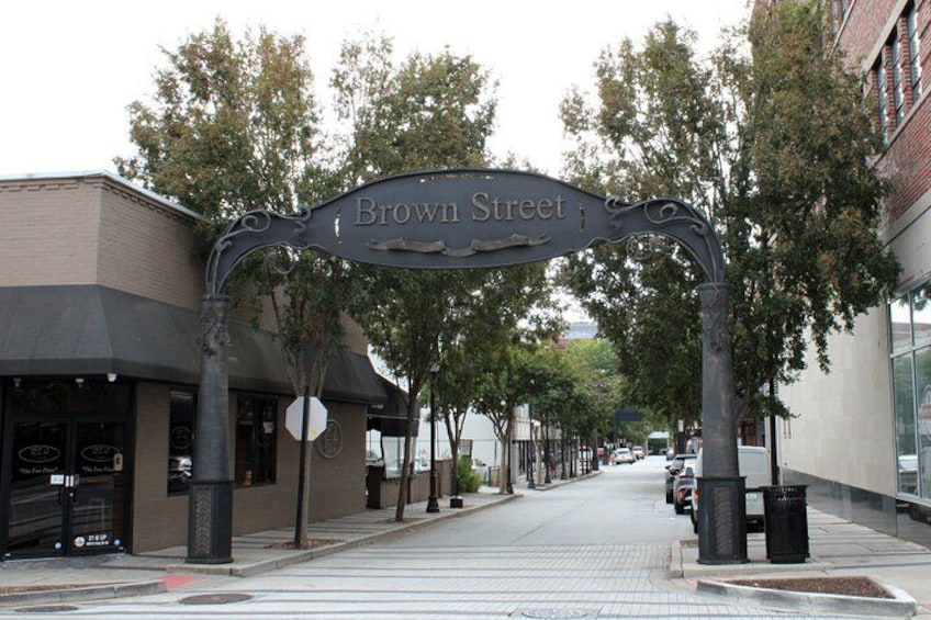 A street sign for Brown Street, a sidewalk, trees, and buildings. 2