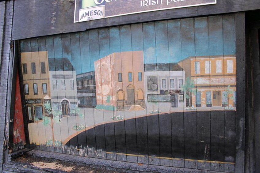 A mural of a street scene with buildings and a road. 5