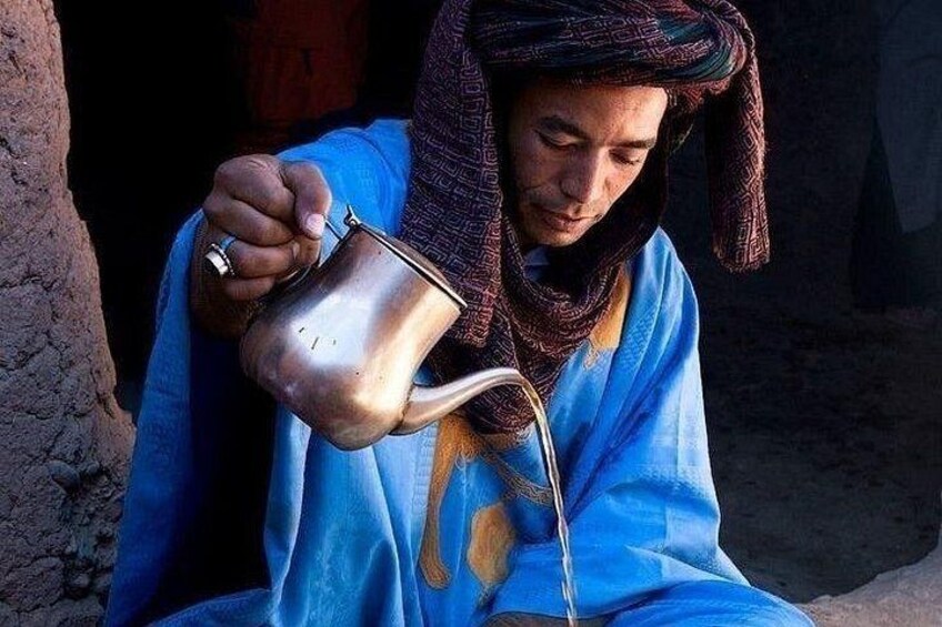 A person pouring liquid from a metal jug. 1