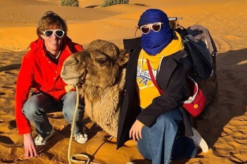 Two people in a desert with a camel. 5