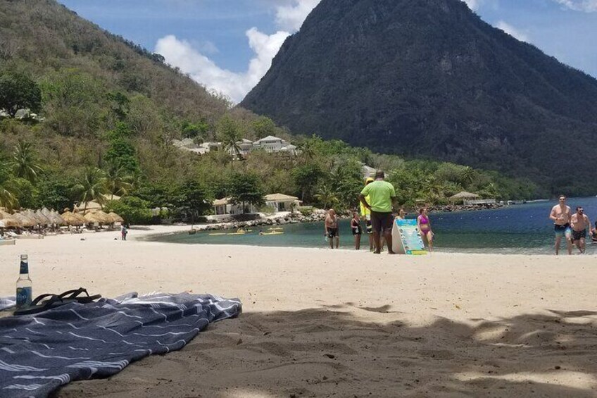 A beach with people, a mountain, and houses in the background. 3