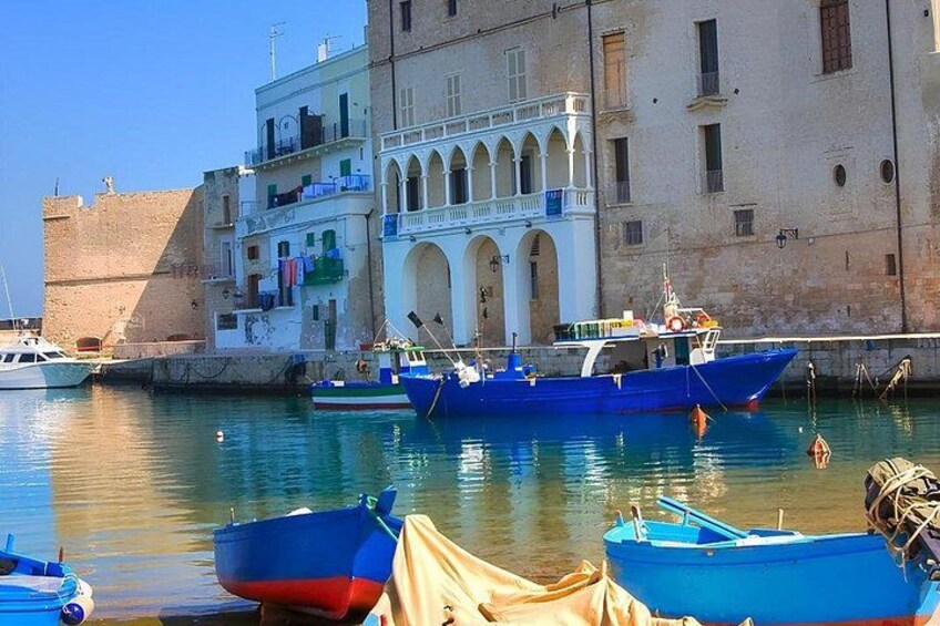 A harbor with boats, a building with arches, and a clear sky. 2