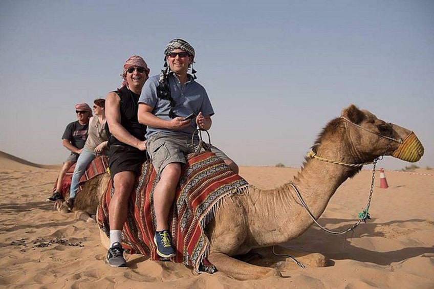 A camel with riders in a desert. 5